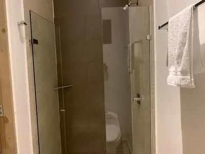 a bathroom with a glass shower with a toilet at Hotel Boutique M in Barranquilla