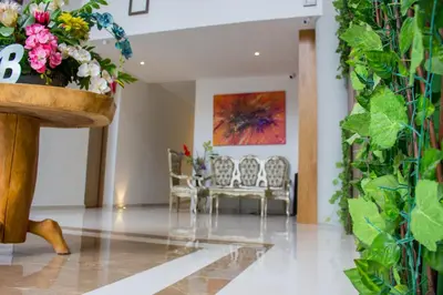 a living room with chairs and a potted plant at Hotel Boutique M in Barranquilla