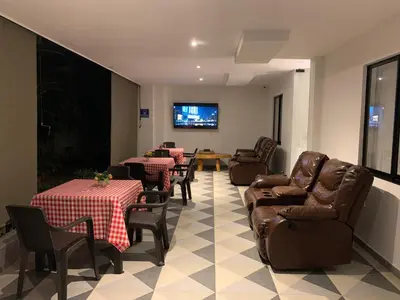 a waiting room with tables and chairs and a flat screen tv at Hotel Boutique M in Barranquilla