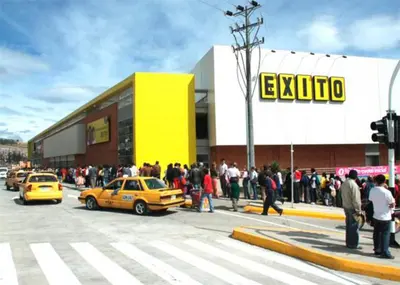 a group of people crossing a street in front of a store at La Quinta Bacana in Barranquilla