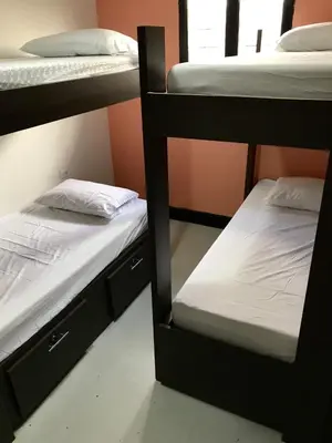a room with two bunk beds with white sheets at La Quinta Bacana in Barranquilla