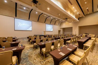 a conference room with tables and chairs and a projection screen at Radisson Cartagena Ocean Pavillion Hotel in Cartagena de Indias