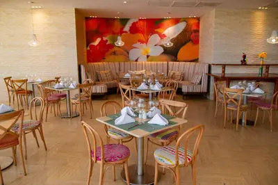 a dining room with tables and chairs and a painting at Radisson Cartagena Ocean Pavillion Hotel in Cartagena de Indias