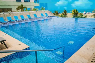 a large swimming pool with chairs and blue chairs at Radisson Cartagena Ocean Pavillion Hotel in Cartagena de Indias