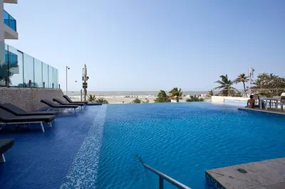 a large swimming pool with chairs in a building at Bello apartamento dentro del Hotel Radisson Ocean Pavillion in Cartagena de Indias