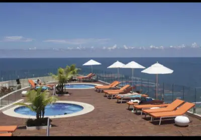a row of chairs and umbrellas next to a swimming pool at Bello apartamento dentro del Hotel Radisson Ocean Pavillion in Cartagena de Indias