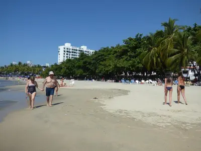 a group of people walking on the beach at Costa Azul Suites 403 in Santa Marta