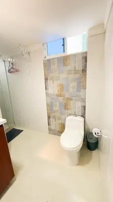 a white bathroom with a toilet and a window at Hermoso Apartamento en Bocagrande-Cartagena in Cartagena de Indias