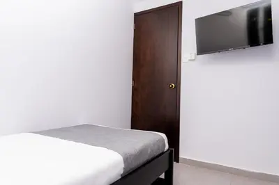 a bedroom with a bed and a flat screen tv at Casa Prado 59 in Barranquilla