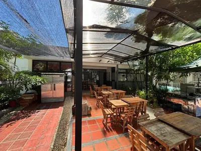 an outdoor patio with wooden tables and wooden chairs at Casa Prado 59 in Barranquilla