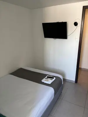 a bedroom with a bed with a flat screen tv on the wall at Casa Prado 59 in Barranquilla