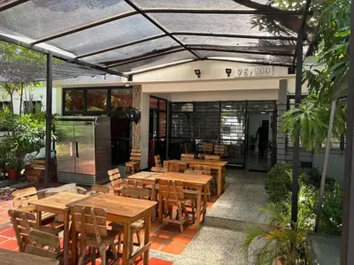 an outdoor patio with wooden tables and wooden chairs at Casa Prado 59 in Barranquilla