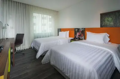 a hotel room with two beds and a desk at Hampton by Hilton Barranquilla in Barranquilla