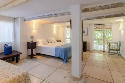 a bedroom with a bed and a table and a chair at Hotel Playa Manglares Isla Baru in Baru
