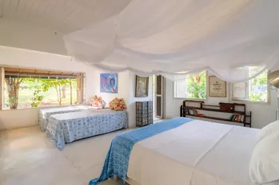 a white bedroom with two beds and a desk at Hotel Playa Manglares Isla Baru in Baru