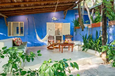 a room with a hammock in a blue house at Hotel Playa Manglares Isla Baru in Baru