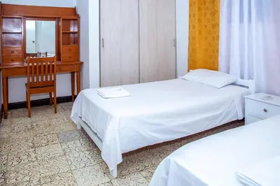 a bedroom with two beds and a desk and a chair at Aqui me quedo in Cartagena de Indias