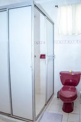 a bathroom with a red toilet and a shower at Aqui me quedo in Cartagena de Indias