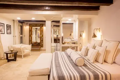 a bedroom with a large bed and a living room at Leones de Alba Hotel Boutique in Cartagena de Indias