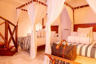 two beds in a room with white curtains at Leones de Alba Hotel Boutique in Cartagena de Indias