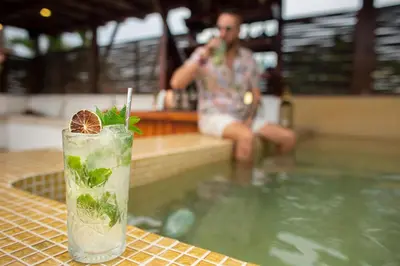 a drink sitting on a table next to a swimming pool at Leones de Alba Hotel Boutique in Cartagena de Indias