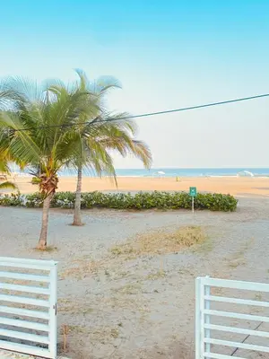 two palm trees and a white fence on a beach at Apartamento en cartagena Boquilla vista al mar dos Hab in Cartagena de Indias