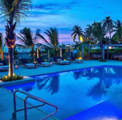 a swimming pool with palm trees in a resort at Apartamento en cartagena Boquilla vista al mar dos Hab in Cartagena de Indias