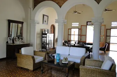 a living room with white chairs and a table at Casa Bustamante Hotel Boutique in Cartagena de Indias