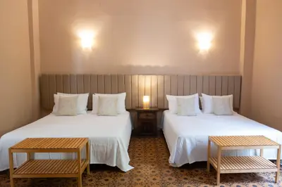 two beds in a room with two tables at Casa Bustamante Hotel Boutique in Cartagena de Indias