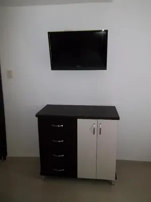 a black and white cabinet with a flat screen tv on a wall at Hotel Golden House in Barranquilla