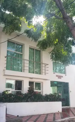 a white building with windows and a balcony at Hotel Golden House in Barranquilla