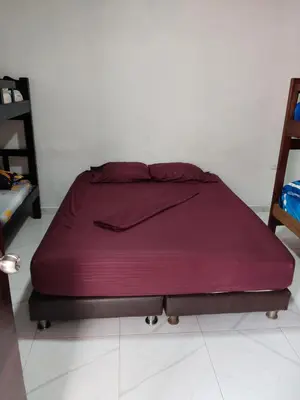 a bed in a room with a purple bedspread at LA MEDELLIN HOSTAL in Cartagena de Indias