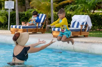 a woman and a child playing in a swimming pool at Hotel Cocoliso Island Resort in Isla Grande