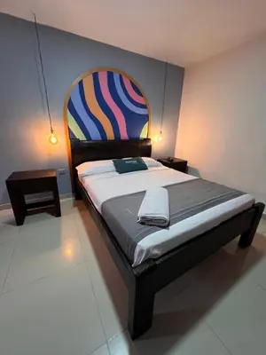a bedroom with a bed with a striped headboard at Hotel Puerto Colombia in Puerto Colombia