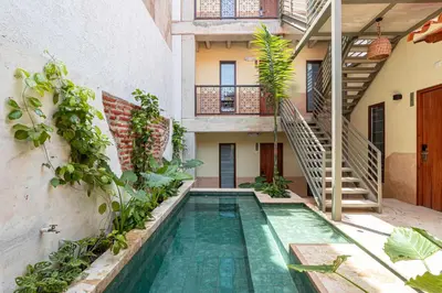 a swimming pool in the middle of a building with plants at Soy Local Insignia in Cartagena de Indias