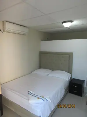 a bedroom with a bed with white sheets and pillows at Hotel Del Mar Inn in Barranquilla