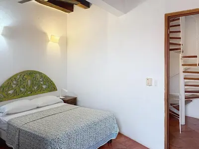 a white bedroom with a bed and a staircase at Casa Digna in Cartagena de Indias