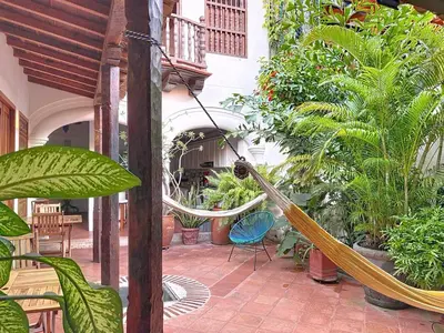 a hammock in the middle of a courtyard with plants at Casa Digna in Cartagena de Indias
