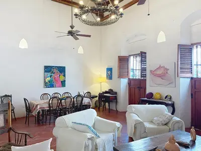 a living room with white furniture and a table and chairs at Casa Digna in Cartagena de Indias