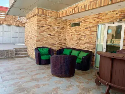 a patio with two chairs with green cushions at Atlantic Garden Hotel in Barranquilla