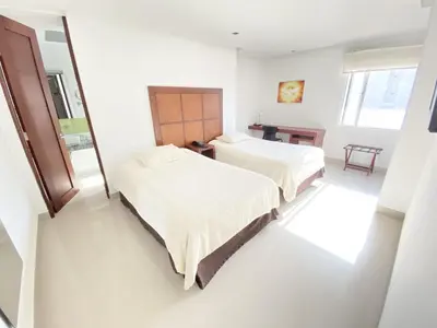 two beds in a room with white walls at Atlantic Garden Hotel in Barranquilla