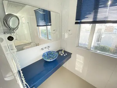 a bathroom with a blue sink and a mirror at Atlantic Garden Hotel in Barranquilla