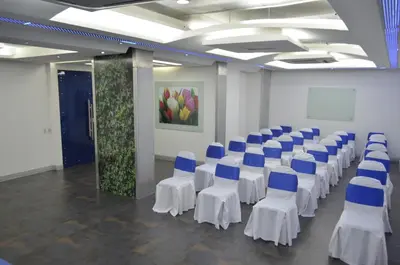 a room with rows of chairs with blue and white tables at Atlantic Garden Hotel in Barranquilla