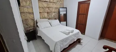 a small bedroom with a white bed with a table at Casa Francia in Cartagena de Indias