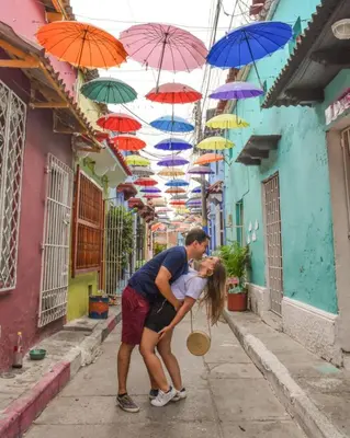 a man and a woman kissing under umbrellas at Casa Francia in Cartagena de Indias