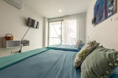 a bedroom with two beds and a tv on the wall at Edificio Morros Vitri Lujo con Panorama in Cartagena de Indias