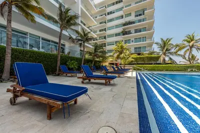 a row of blue lounge chairs next to a swimming pool at Edificio Morros Vitri Lujo con Panorama in Cartagena de Indias