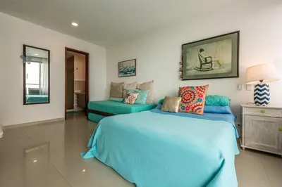 a bedroom with a blue bed and a couch at Edificio Morros Vitri Lujo con Panorama in Cartagena de Indias