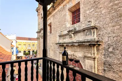 a bottle of wine sitting on a balcony at Casa San Pedro - Exclusive 3BR Colonial Apt in Centro Historico by Huespedia in Cartagena de Indias