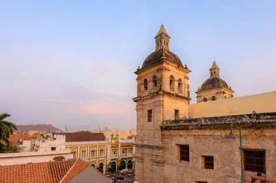 an old building with a clock tower on top of it at Casa San Pedro - Exclusive 3BR Colonial Apt in Centro Historico by Huespedia in Cartagena de Indias